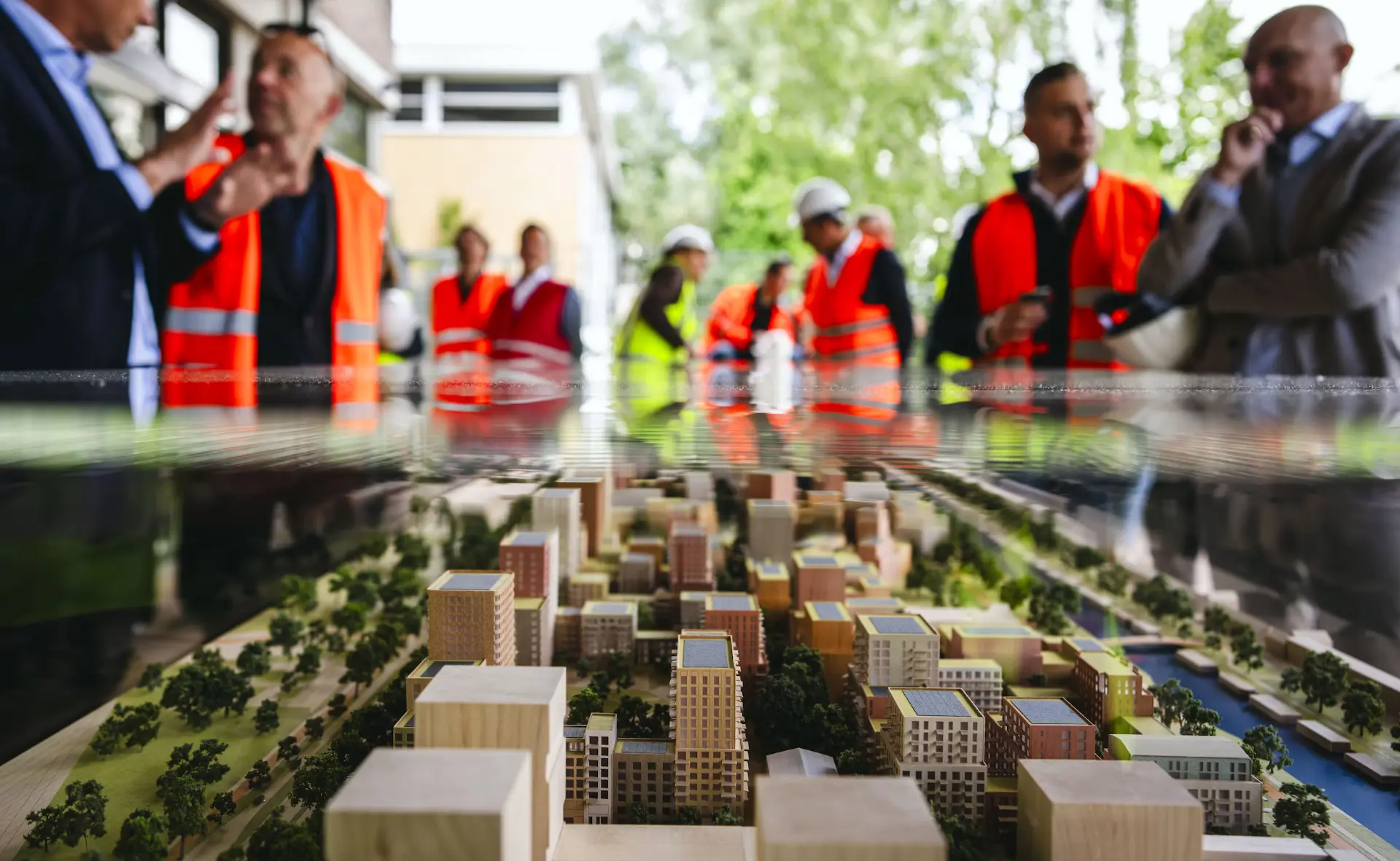 Gemeente en partners in overleg rond een maquette van een wijk